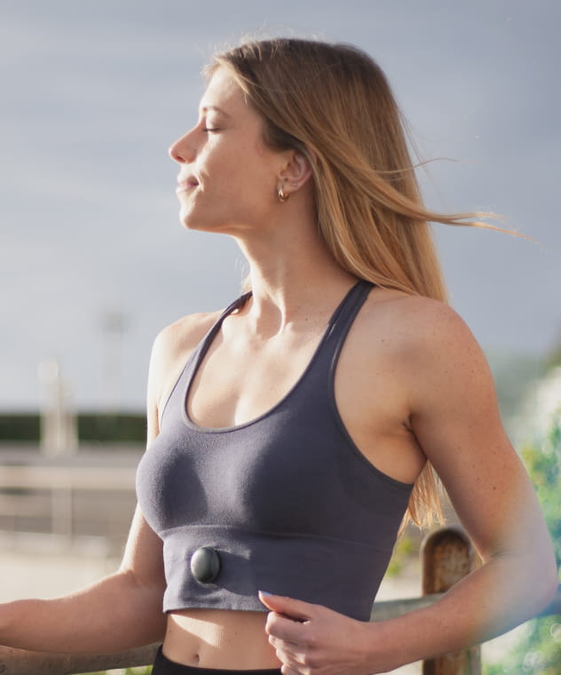 Woman outdoors showcasing the Oxa wearable breathing coach device