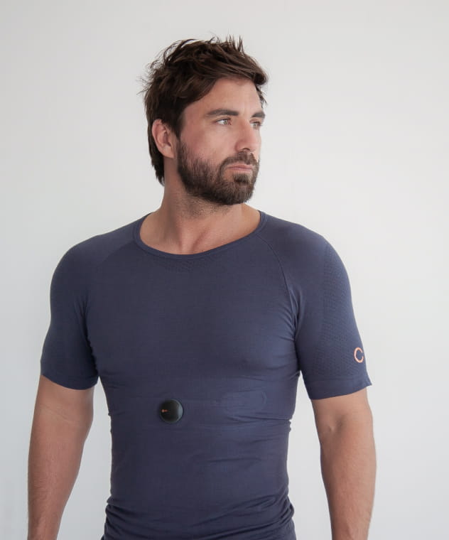 Focused man wearing the integrated sensor-equipped Oxa lounge shirt, designed for real-time breathing coaching and stress management