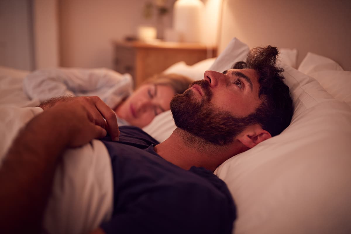 Couple experiencing sleep issues with a focus on sleep health.